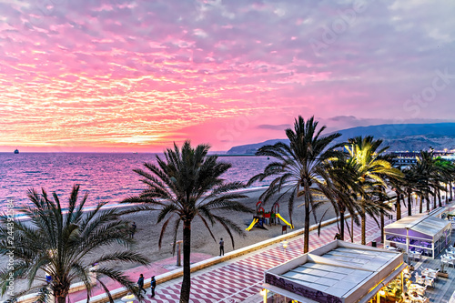 Dramatic Mediterranean sunset on Almeria beach promenade.