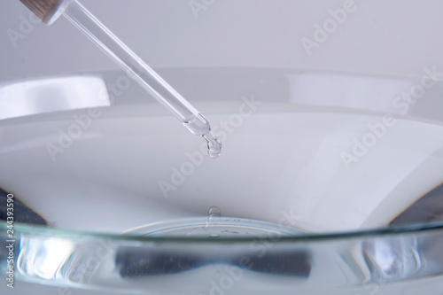 Pipette drops a drop into the water of a large bowl