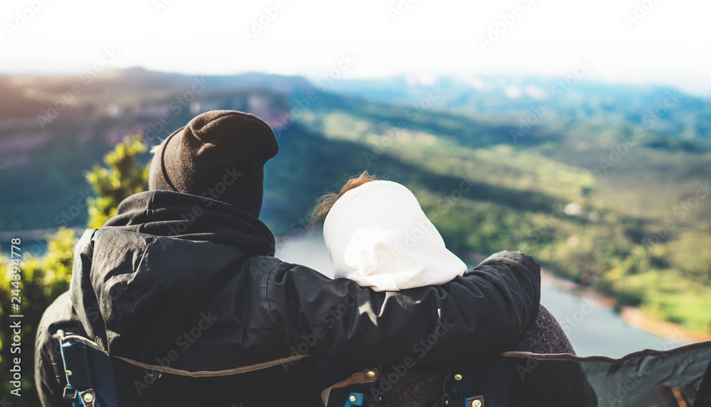 Couple hugging two romantic people cuddling and looking panoramic landscape of sun flare mountain, travelers weekend concept, hipster enjoy nature together, travel holidays vacation Couple hugging two romantic people cuddling and looking panoramic landscape of sun flare mountain, travelers weekend concept, hipster enjoy nature together, travel holidays vacation