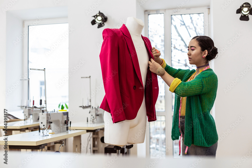 Obraz premium Cute asian dark-haired dressmaker with bright makeup looking serious