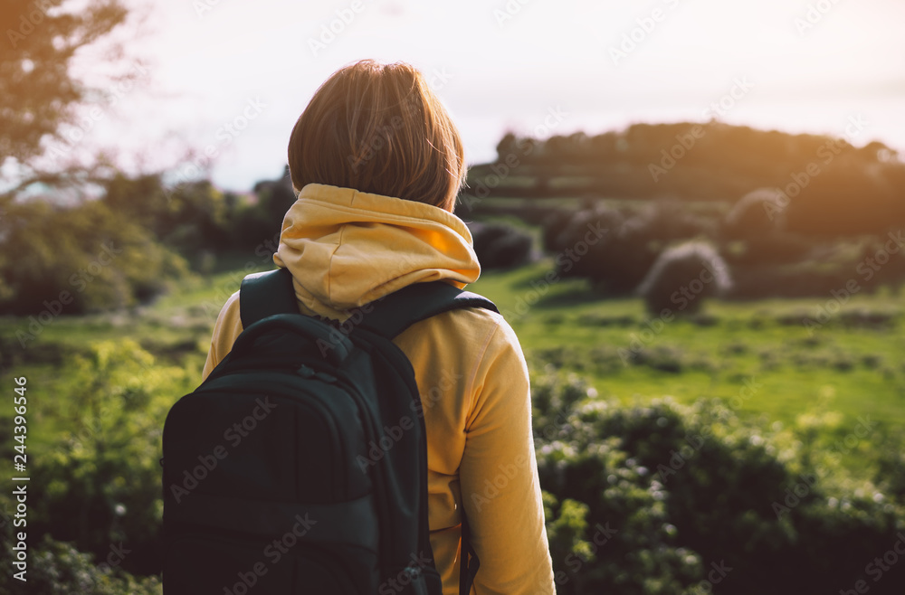tourist traveler with backpack standing on green top on mountain, hiker view from back looking on hills and mountain river lake, girl enjoying nature panoramic landscape in trip, relax holiday concept