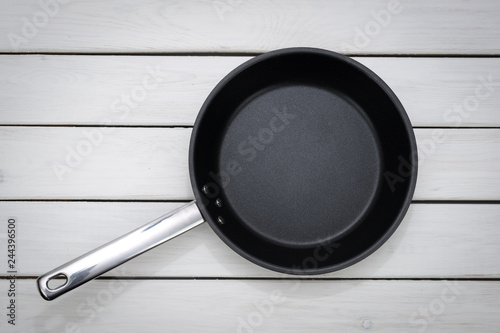 Culinary template - top view of an empty pan on a white wooden plank background. 
