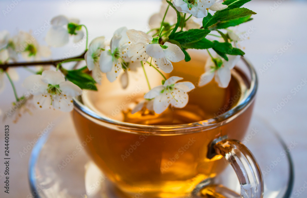 Tea. green. Herbal. Mint. Tea with apple flavor. in a glass cup with an apple flower and dried tea leaves sliced lime. herbal tea and mint leaves on a slate plate in a restaurant Tea. green. Herbal. Mint. Tea with apple flavor. in a glass cup with an apple flower and dried tea leaves sliced lime. herbal tea and mint leaves on a slate plate in a restaurant
