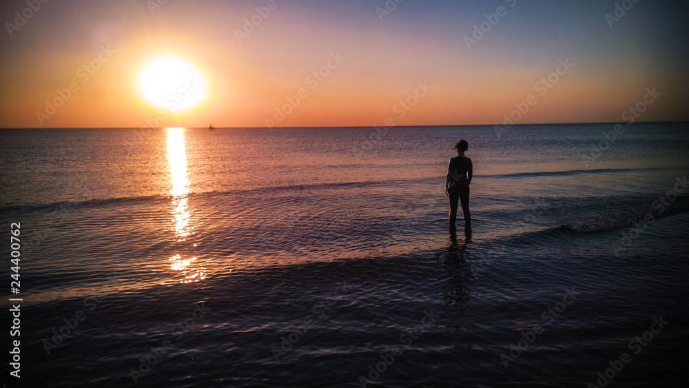 girl with a wet suit at sunset