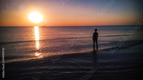 girl with a wet suit at sunset
