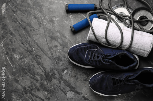 Shoes, sport equipment and towel on grey background