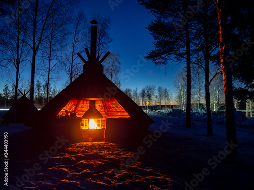 Lapland shelter with fireplace in winter night