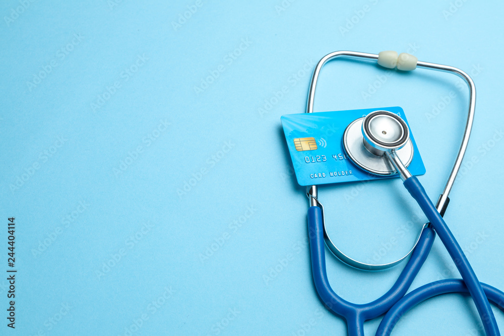 Credit card with stethoscope on blue background. The concept of medical strechevka or expensive medicine, doctors salary. Copy space for text. - obrazy, fototapety, plakaty 