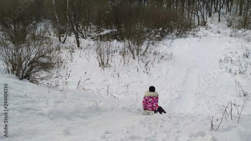 Girl rides down a hill on a sled