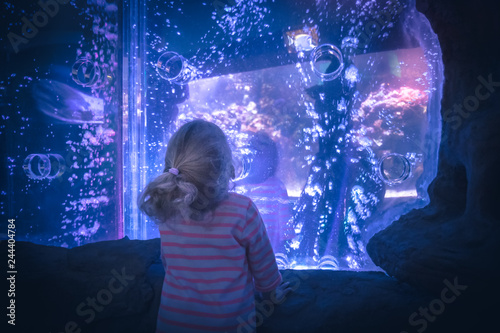 Surprised excited child looking with admiration lilac blue futuristic water view like portal into another reality  concept admiration amazement curiosity photo