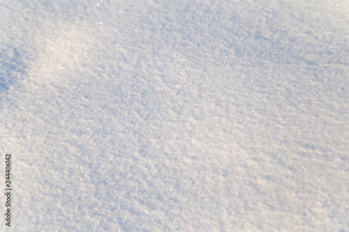 Background of white snow sparkling in the sun. Shallow depth of field © Olga Lipatova