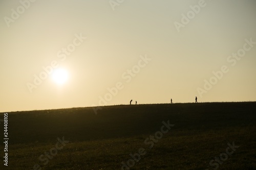 People walking on a meadow during sunset. Slovakia 