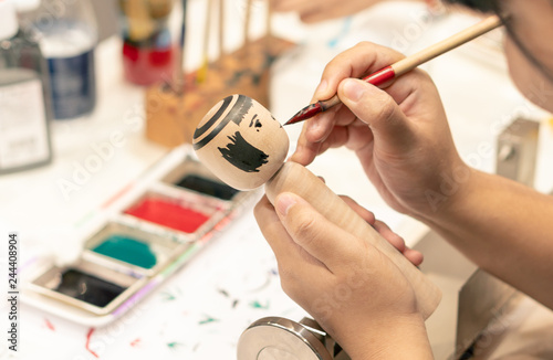 Bangkok, Thailand - SEP 01, 2018 : people making Japanese Kokeshi dolls in the art workshop class, Japan traditional adorable souvenir toys for tourist photo