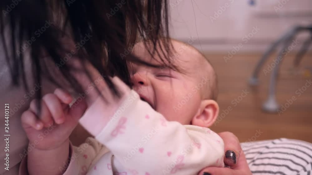 Baby girl child has fun enjoy play try to catch mother brunette hair - happy motherhood