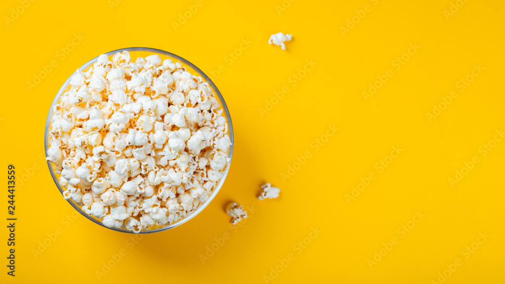 Glass bowl with salted popcorn on yellow background. Top view with copy space. Flat lay Glass bowl with salted popcorn on yellow background. Top view with copy space. Flat lay