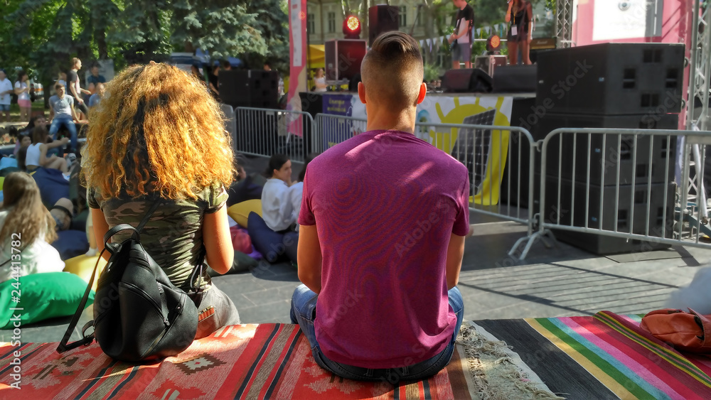 Two young people at a rock concert. A teen couple at a summer music festival. Full color