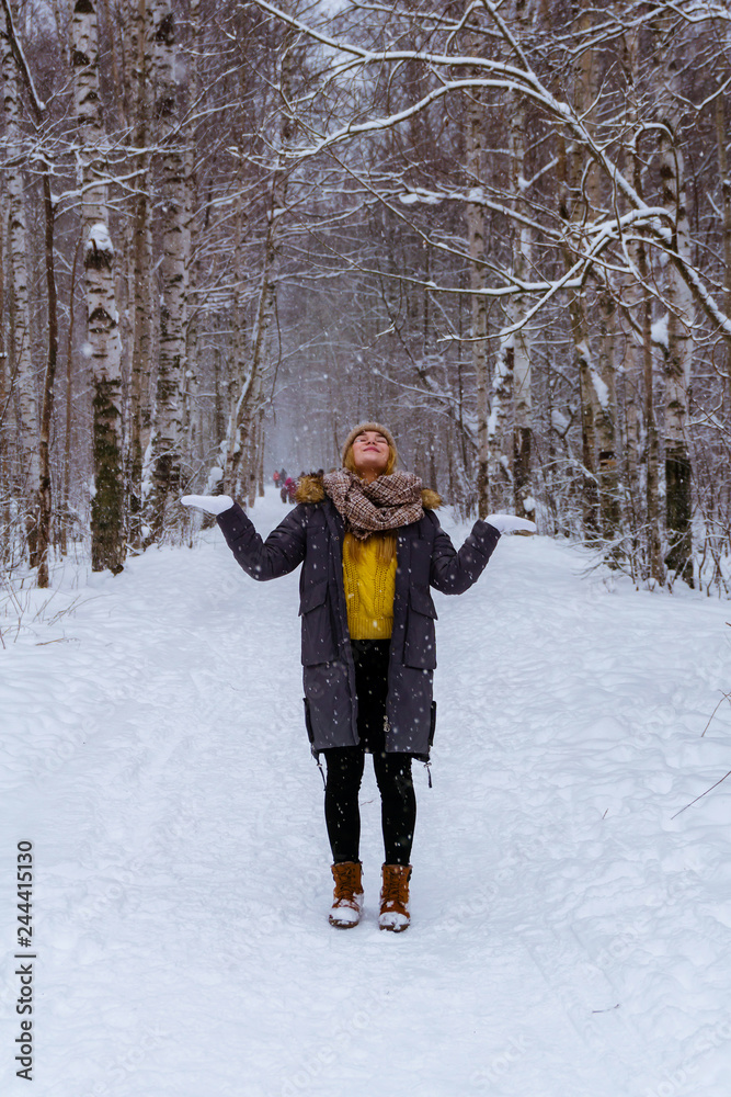 girl catches snowflakes in the winter park