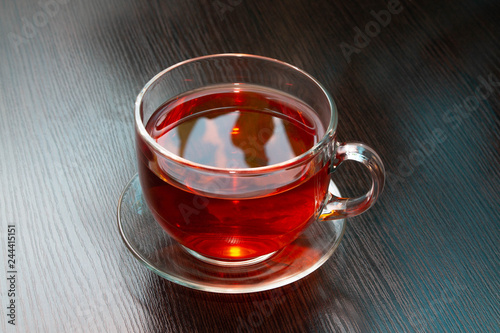 hot black tea in a Cup on a dark brown wooden table