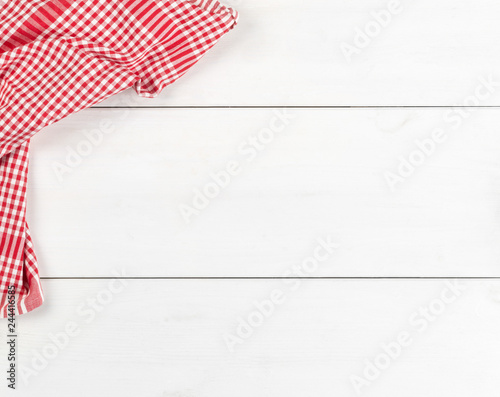 Red checkered dishcloth on white wooden plank table flat lay top view from above