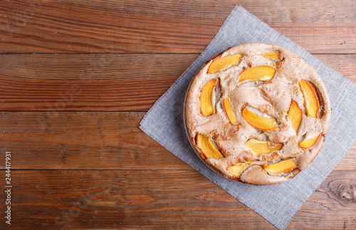 Sweet persimmon pie on brown wooden background.