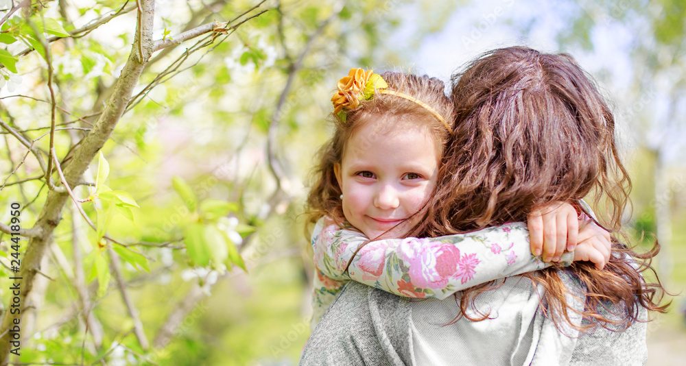 Daughter hugs mom. Happy woman holding a little girl in her arms. Beautiful mother with her daughter on Mother's Day. Daughter hugs mom. Happy woman holding a little girl in her arms. Beautiful mother with her daughter on Mother's Day.