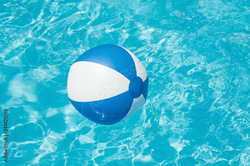 Inflatable colorful ball floating in a swimming pool © dziewul
