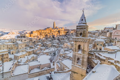 panoramic view of typical stones Sassi di Matera and church of Matera 2019 under blue sky with clouds and snow on the house, concept of travel and christmas holiday,capital of europe culture 2019