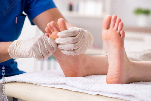 Podiatrist treating feet during procedure photo