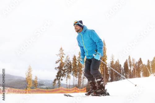 Male skier on slope at resort, space for text. Winter vacation