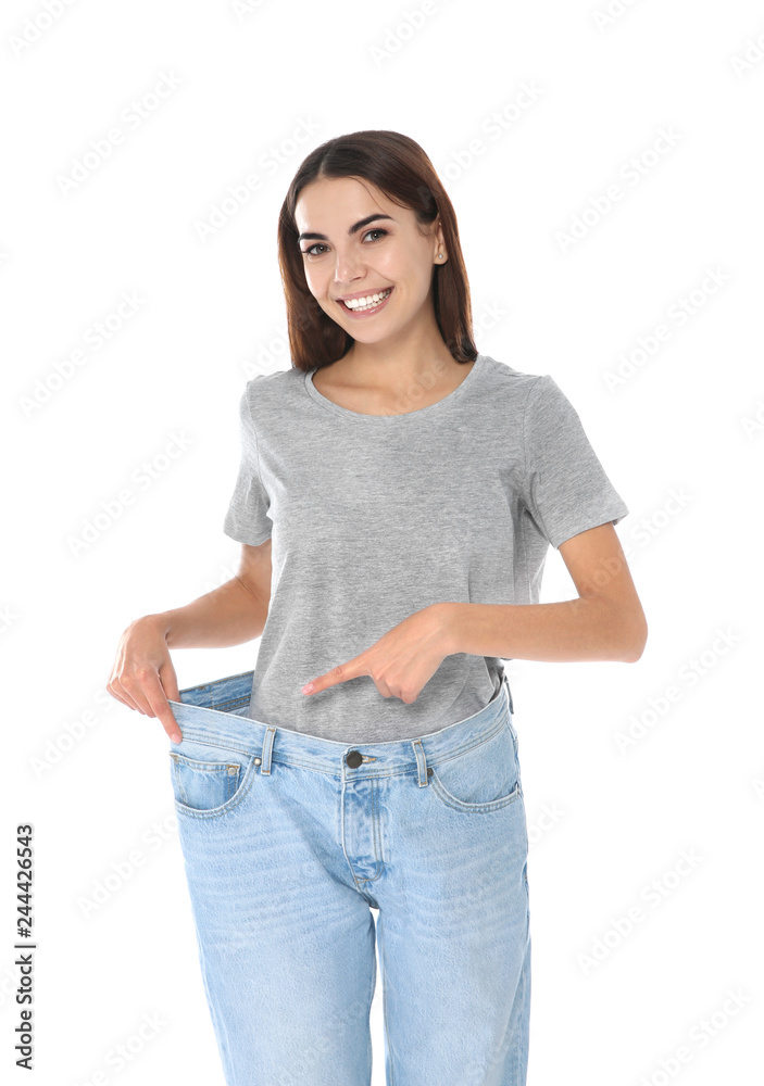 Slim woman in oversized jeans on white background. Weight loss Slim woman in oversized jeans on white background. Weight loss