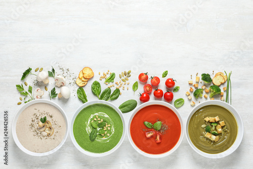 Flat lay composition with various soups, ingredients and space for text on white background. Healthy food