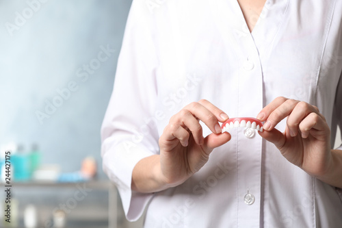 Dentist holding teeth cover on blurred background, closeup Fotobehang