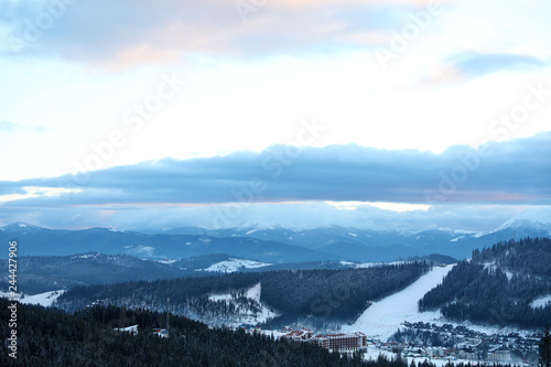 Beautiful mountain landscape with forest and ski resort in winter