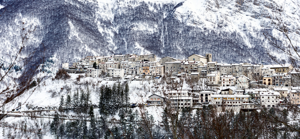 Aerial view of the beautiful snow-covered village of Opi with snow-capped mountains in the background. Opi is a comune and town in the province of L'Aquila in the Abruzzo region of central Italy.