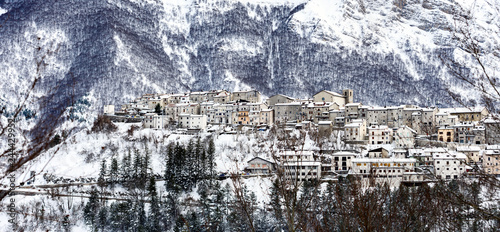 Obraz na płótnie Aerial view of the beautiful snow-covered village of Opi with snow-capped mountains in the background. Opi is a comune and town in the province of L'Aquila in the Abruzzo region of central Italy. w salonie