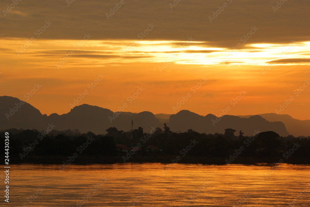 early morning on the river with silhouette mountains and tree