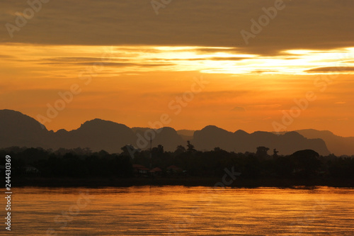 early morning on the river with silhouette mountains and tree