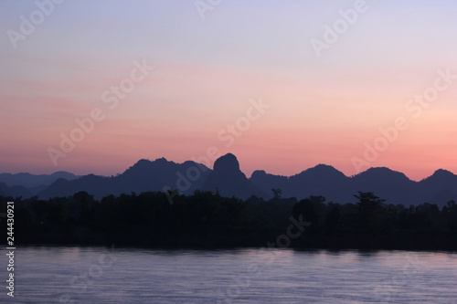 early morning on the river with silhouette mountains and tree