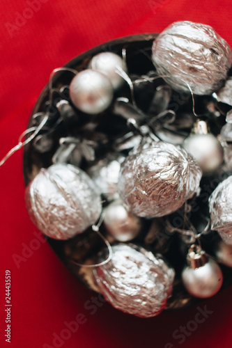 Christmas decoration with silver balls, baubles and pine cones on red background