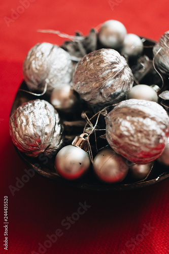 Christmas decoration with silver balls, baubles and pine cones on red background