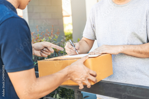 Customer Man signature in clipboard to receive package from professional delivery man at home
