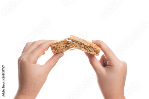 Broken Whole grain wheat biscuits breakfast cereal in hand