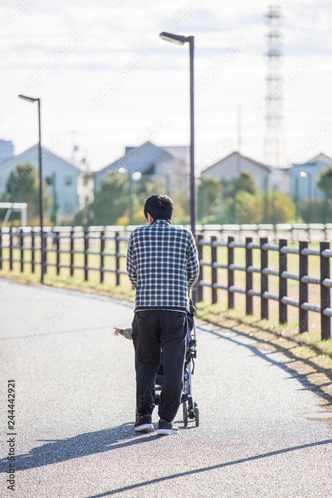 ベビーカーを押す若い父親 ベビーカーを押す若い父親
