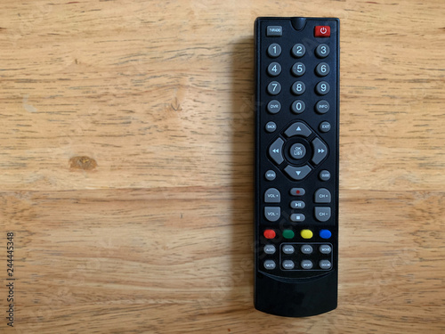 television remote control on wooden table.