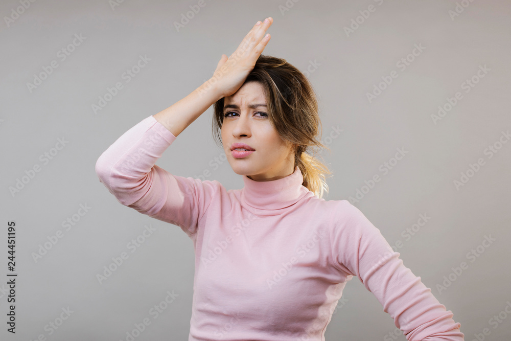 Fototapeta premium Attractive sad young woman with hand on head