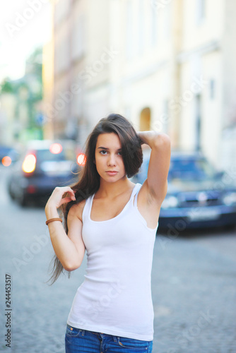 Hipster girl wearing blank white t-shirt and jeans posing against street road, minimalist urban clothing style, mockup for tshirt print store