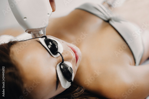 Close up photo of a woman that is doing laser epilation on face photo