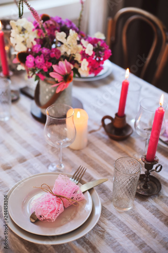 romantic summer dinner in cozy country house. Festive table setting with flowers and candles in purple tones