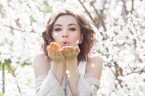 Close up portrait of young beautiful woman on spring background. Attractive young girl with flowers. Spring make up model.
