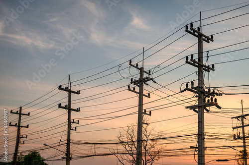 Rural rows of electricity pole with wires network on sunset